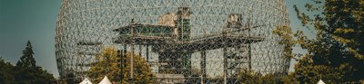 A large structure with a large dome on top of it. The building is the biosphere environmental museum in Montreal, Canada.