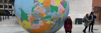 Academic Laura Pulido, stood next to large globe at the London School of Economics.