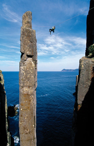 A view of someone on a wire moving across to a coastal stack