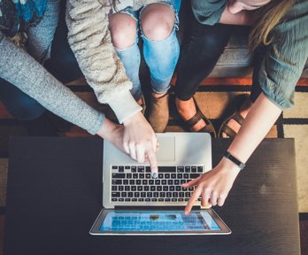 People pointing at a laptop