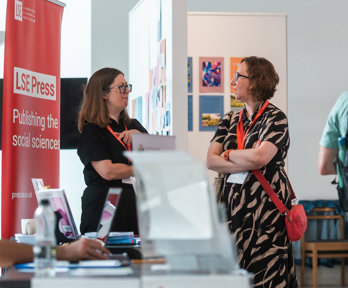 A delegate talks to a publisher's representative in the exhibitors' area