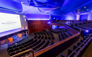 View from the balcony in the Ondaatje Theatre at the Royal Geographical Society. A presentation slide is projected on the screen and says 'Welcome to the Roayl Geographical Society'.