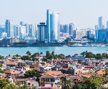 Traditional Chinese buildings and a city with new skyscrapers divided by a river.