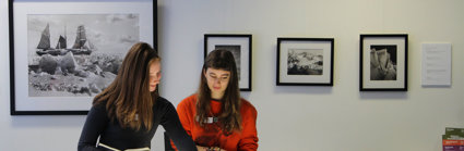 Two people beside a table looking at slides laid on a lightbox.