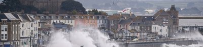 A cornish coastal sea front being battered by large foamy waves