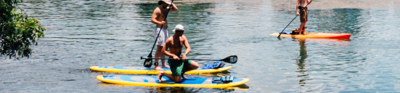 Three people stand up paddle boarding 