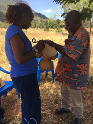 A researcher receiving a guard gift from a community elder.