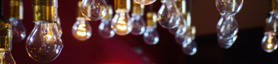 Light bulbs hanging from the ceiling with a dark red background, creating a warm ambiance.