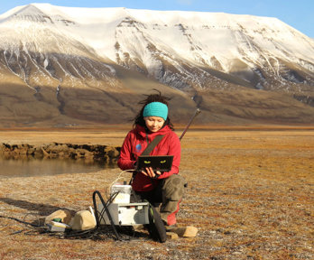 Researcher downloading data from a water monitoring station in Adventdalen.