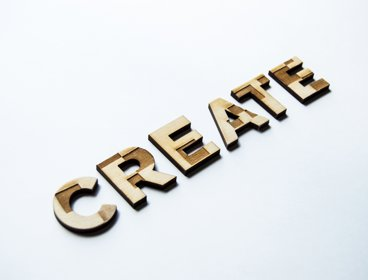 The word 'create' in wood on a white background