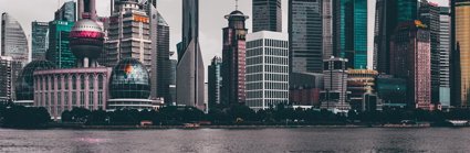 A view of a Chinese city, showing skyscrapers and modern buildings on the banks of a river