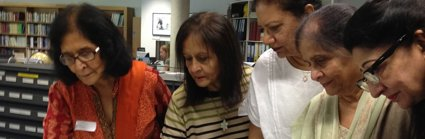 Asian women looking at historic photographs in the Foyle Reading Room