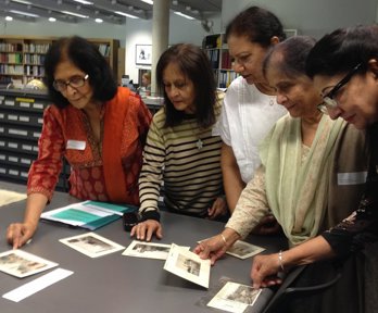 Asian women looking at historic photographs in the Foyle Reading Room