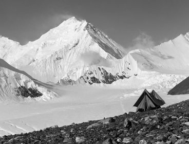 Old black and white photo of Everest with a tent in the foreground.