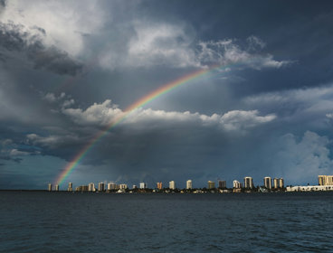 A stormy day where a rainbow can be seen through the clouds